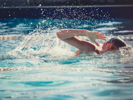 Enfant nageant le crawl dans une piscine